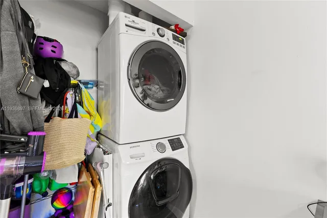 a utility room with dryer washer and a rug