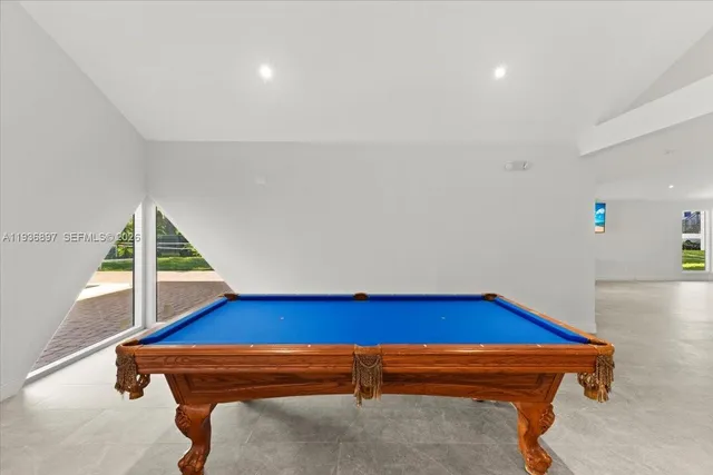 a room with pool table and wooden floor