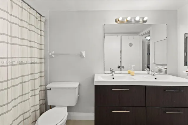 a bathroom with a sink a toilet and mirror