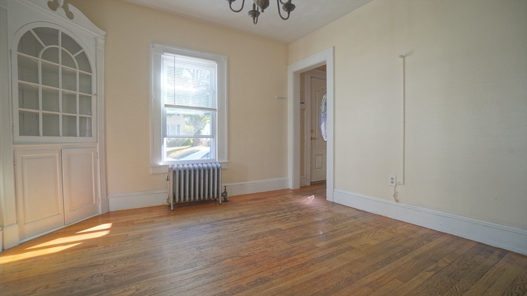 26 Harkness Avenue Springfield, MA 01118 - Photo 12 of 25 an empty room with wooden floor and windows