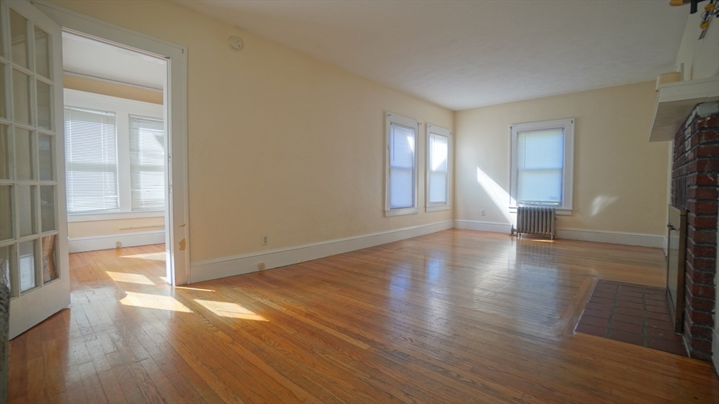 26 Harkness Avenue Springfield, MA 01118 - Photo 6 of 25 an empty room with wooden floor and windows