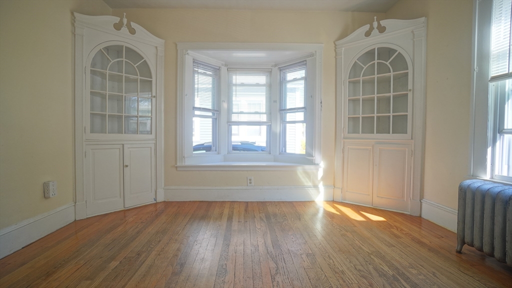 26 Harkness Avenue Springfield, MA 01118 - Photo 10 of 25 an empty room with wooden floor and windows