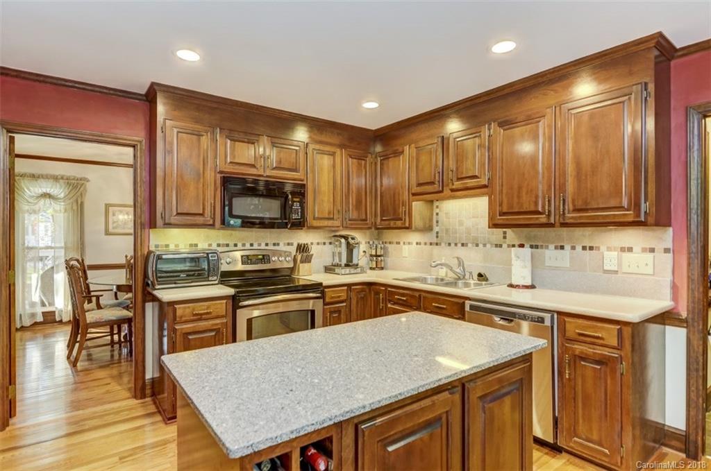 5204 Fowler Farm Road Mint Hill, NC 28227 - Photo 13 of 28 a kitchen with stainless steel appliances granite countertop wooden cabinets a stove top oven a sink and dishwasher
