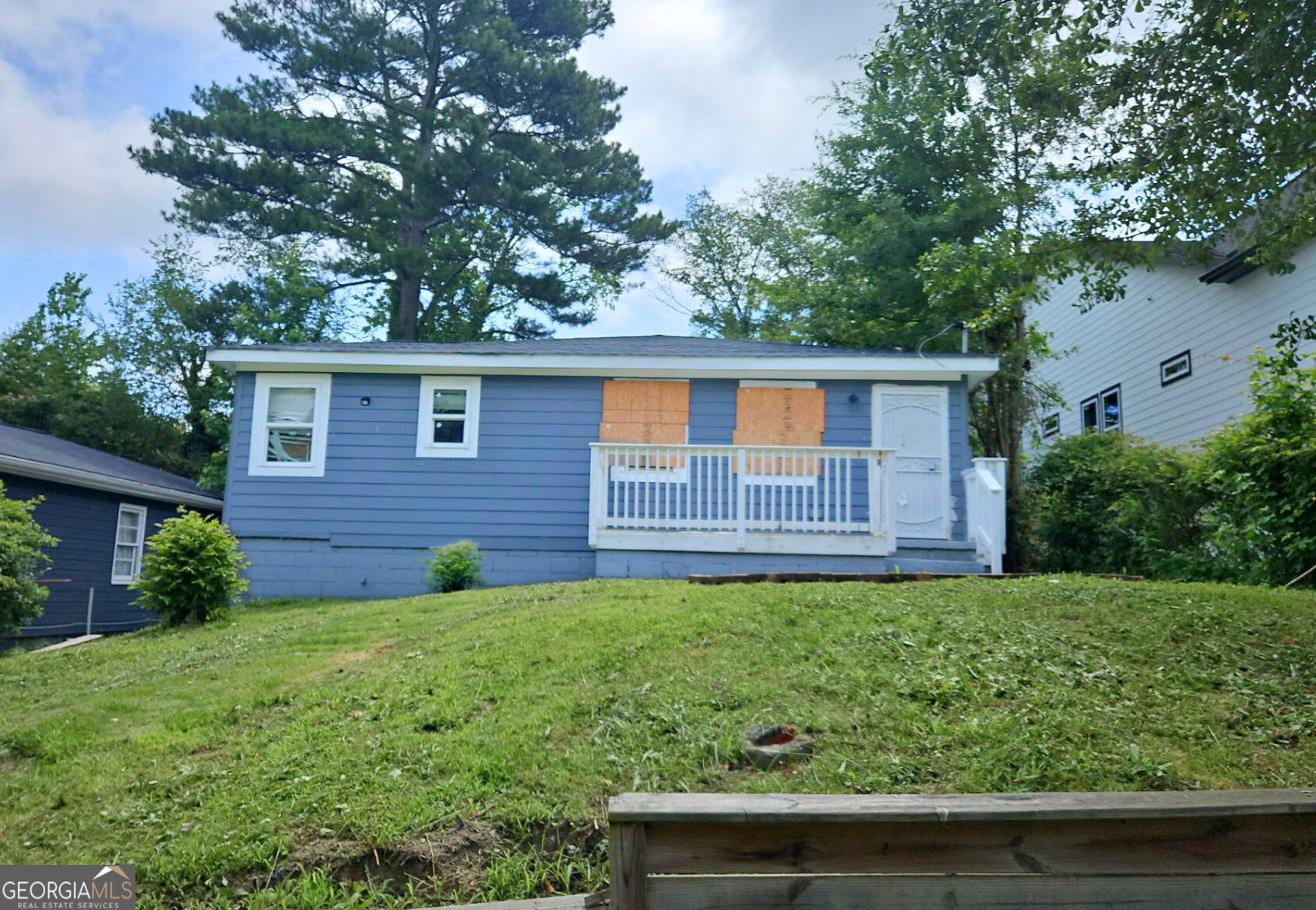 a backyard that has potted plants and a large tree