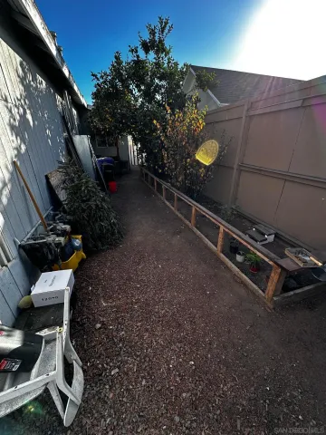 a view of a backyard with chairs and potted plants