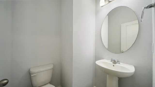 a bathroom with a toilet sink and mirror