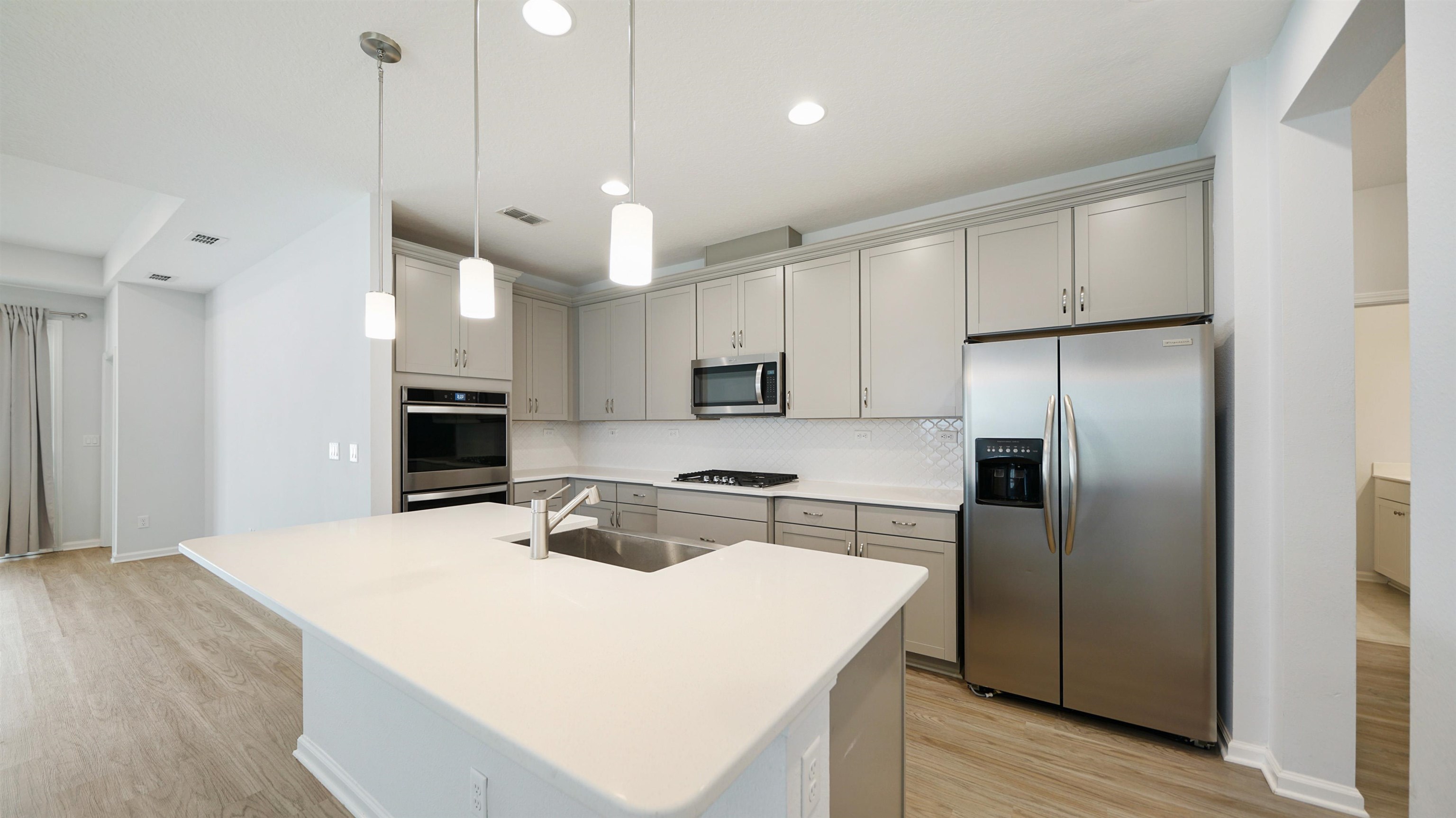 443 Watervale Drive St. Augustine, FL 32092 - Photo 3 of 39 a kitchen with stainless steel appliances granite countertop a refrigerator a sink dishwasher a stove and white countertops with wooden floor