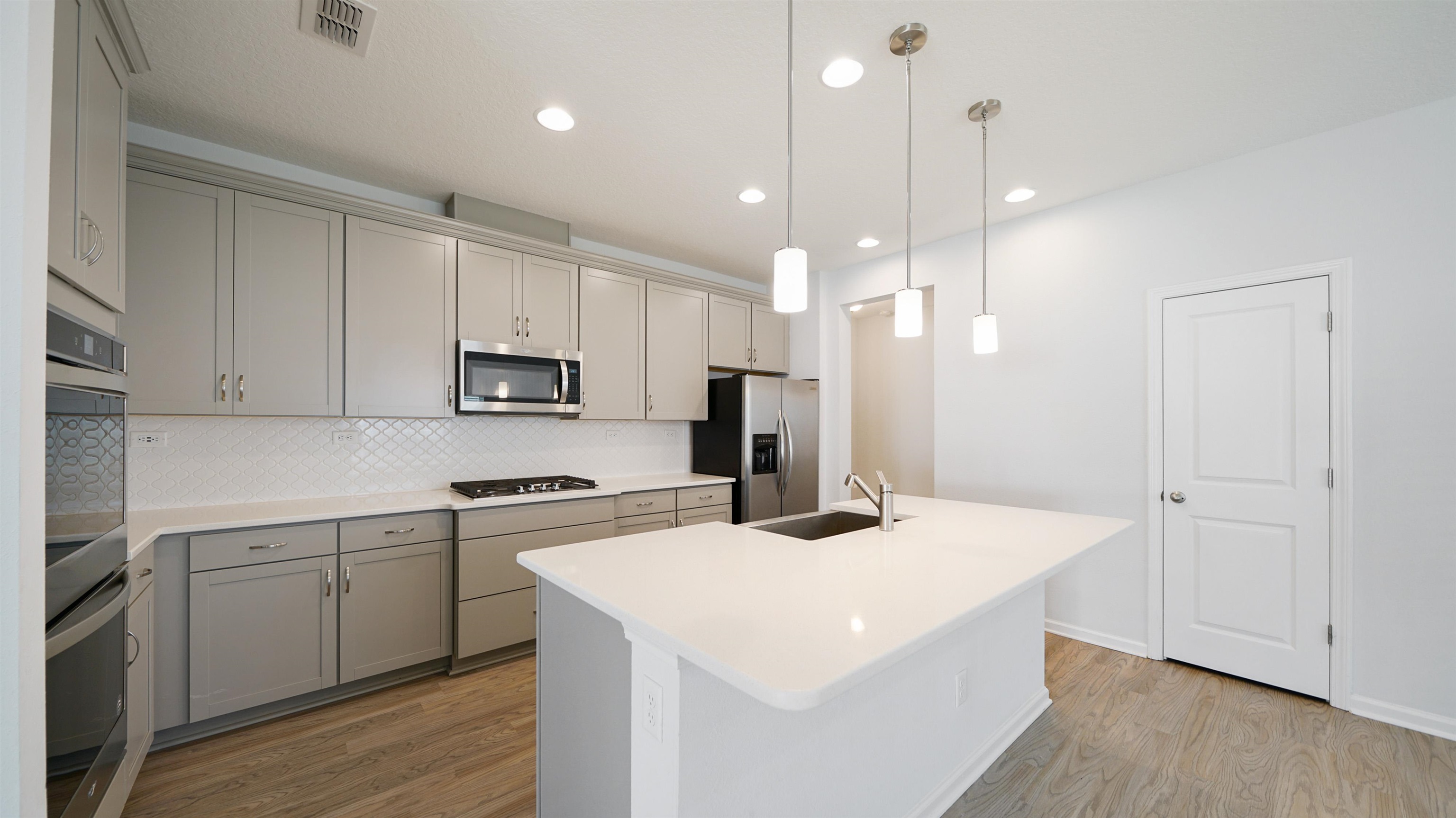 443 Watervale Drive St. Augustine, FL 32092 - Photo 5 of 39 a kitchen with a sink a stove a refrigerator and white cabinets