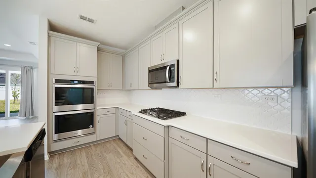 a kitchen with granite countertop white cabinets and stainless steel appliances
