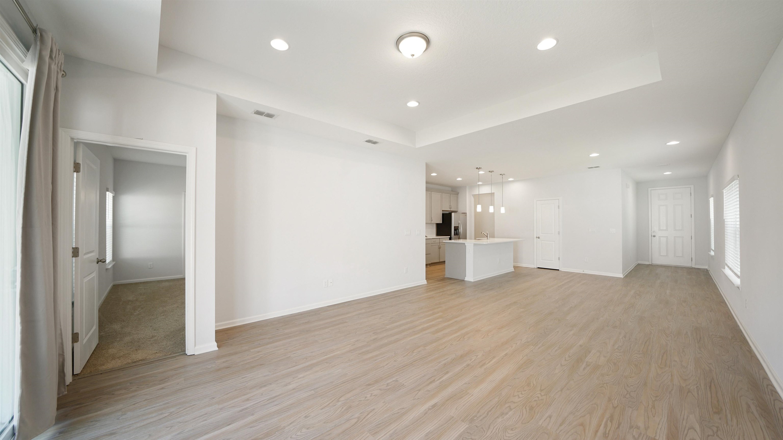 443 Watervale Drive St. Augustine, FL 32092 - Photo 9 of 39 a view of an empty room with wooden floor and a kitchen
