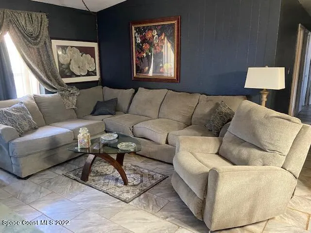 a living room with furniture and painting on the wall
