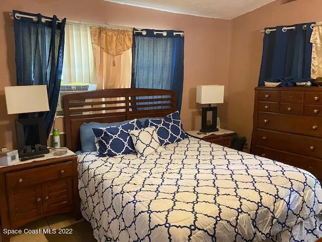 a bedroom with a bed and a flat tv screen on dresser