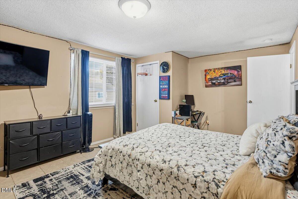 7735 Sandra Lane Raleigh, NC 27615 - Photo 16 of 20 a bedroom with a bed and a television