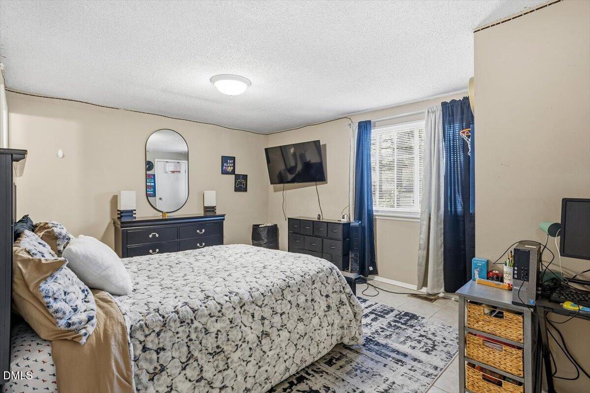 7735 Sandra Lane Raleigh, NC 27615 - Photo 17 of 20 a bedroom with a bed dresser and mirror