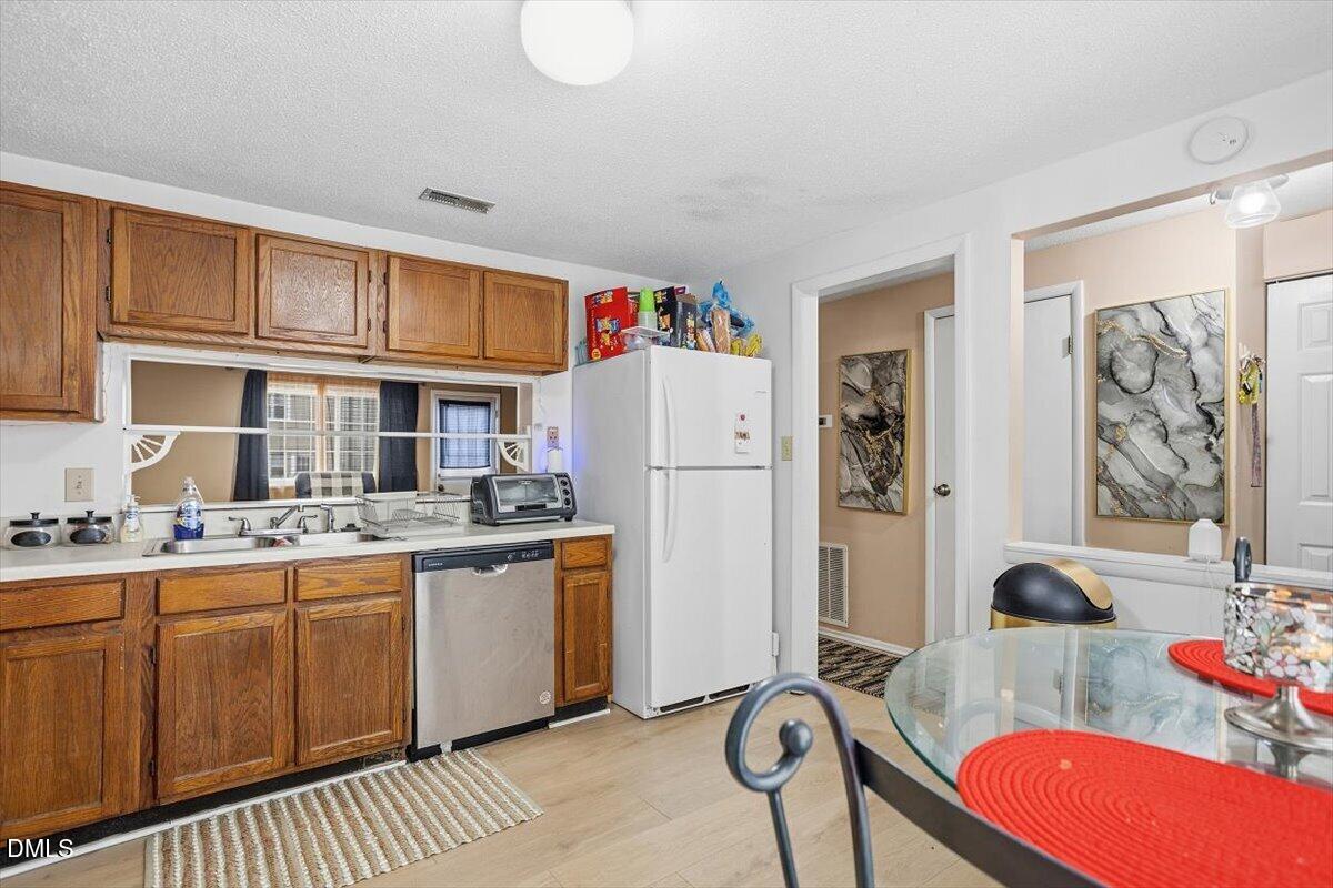 7735 Sandra Lane Raleigh, NC 27615 - Photo 4 of 20 a kitchen with stainless steel appliances granite countertop a sink stove and refrigerator