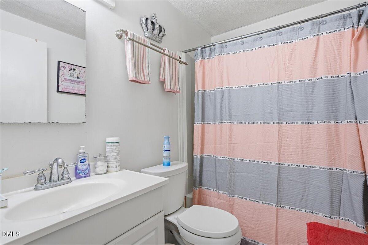 7735 Sandra Lane Raleigh, NC 27615 - Photo 6 of 20 a bathroom with a sink a toilet and shower