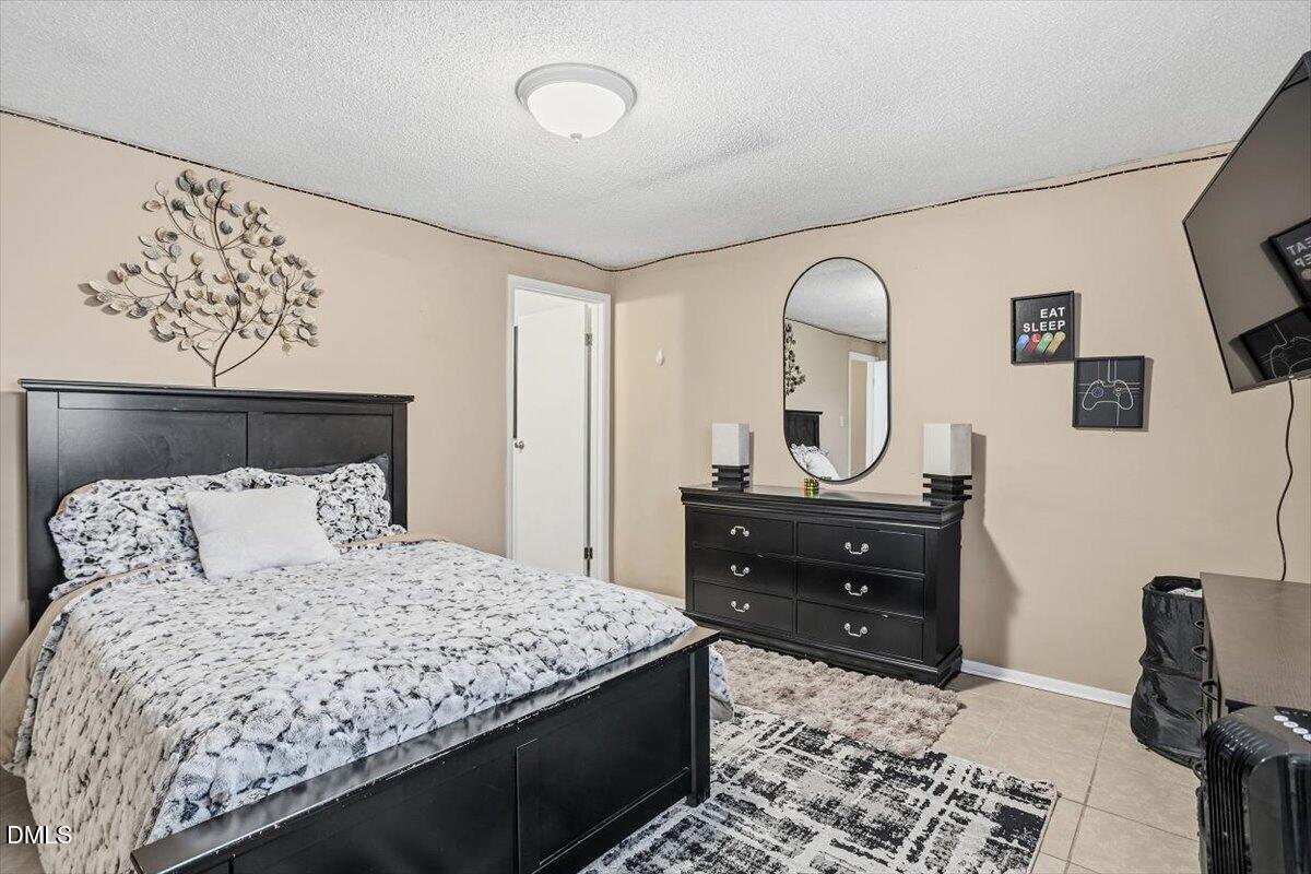 7735 Sandra Lane Raleigh, NC 27615 - Photo 7 of 20 a bedroom with a bed and a dresser