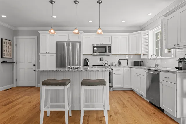 a kitchen with kitchen island granite countertop a sink a center island and cabinets