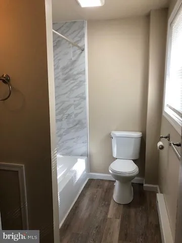 a bathroom with a toilet and a shower