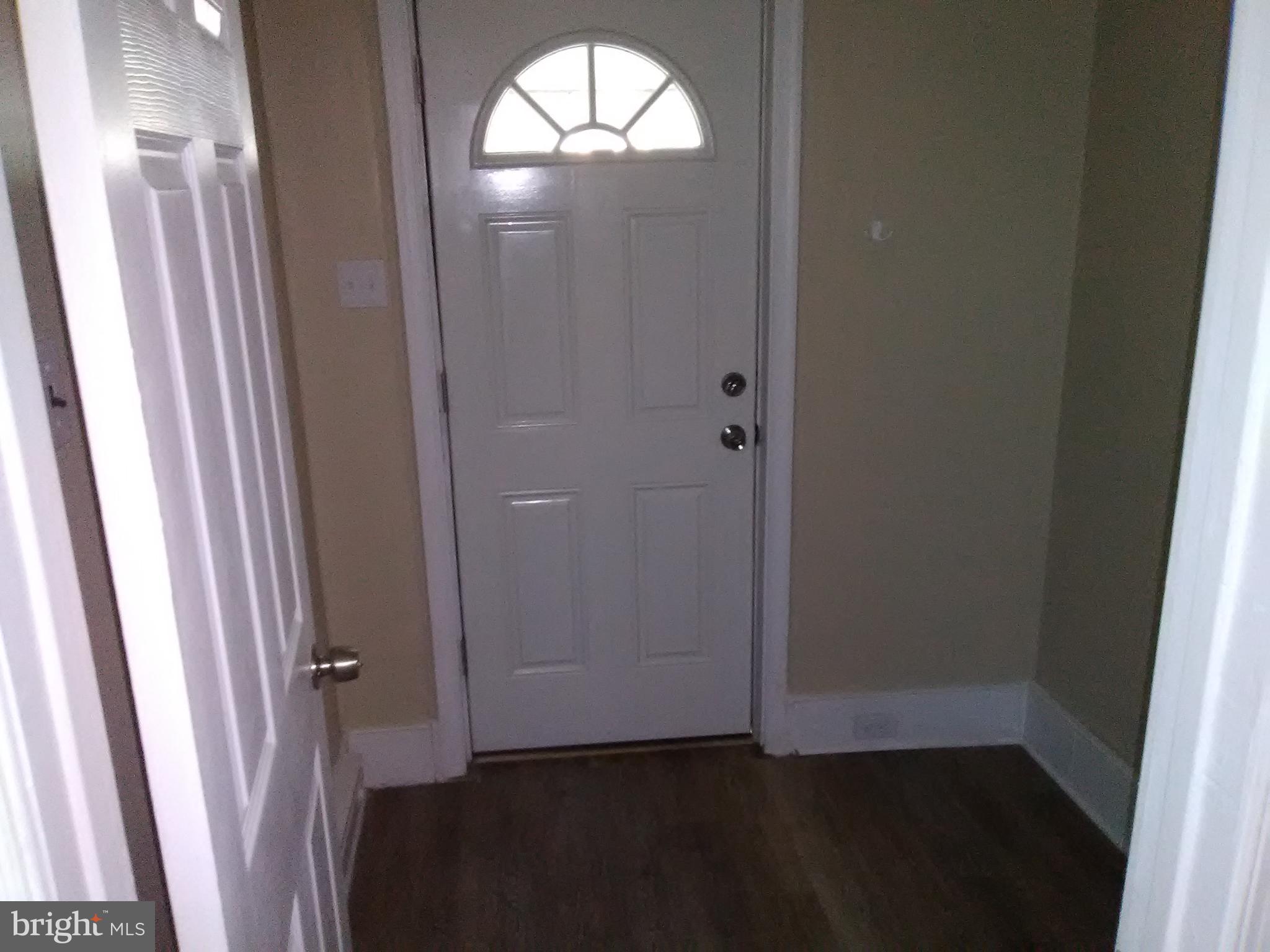102 West Broad Street, Unit 1 Souderton, PA 18964 - Photo 3 of 20 a view of an empty room with wooden floor and a door