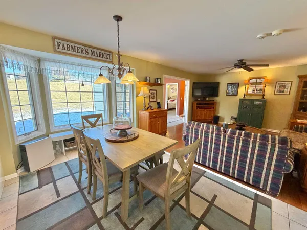 an empty room with a chandelier fan and windows