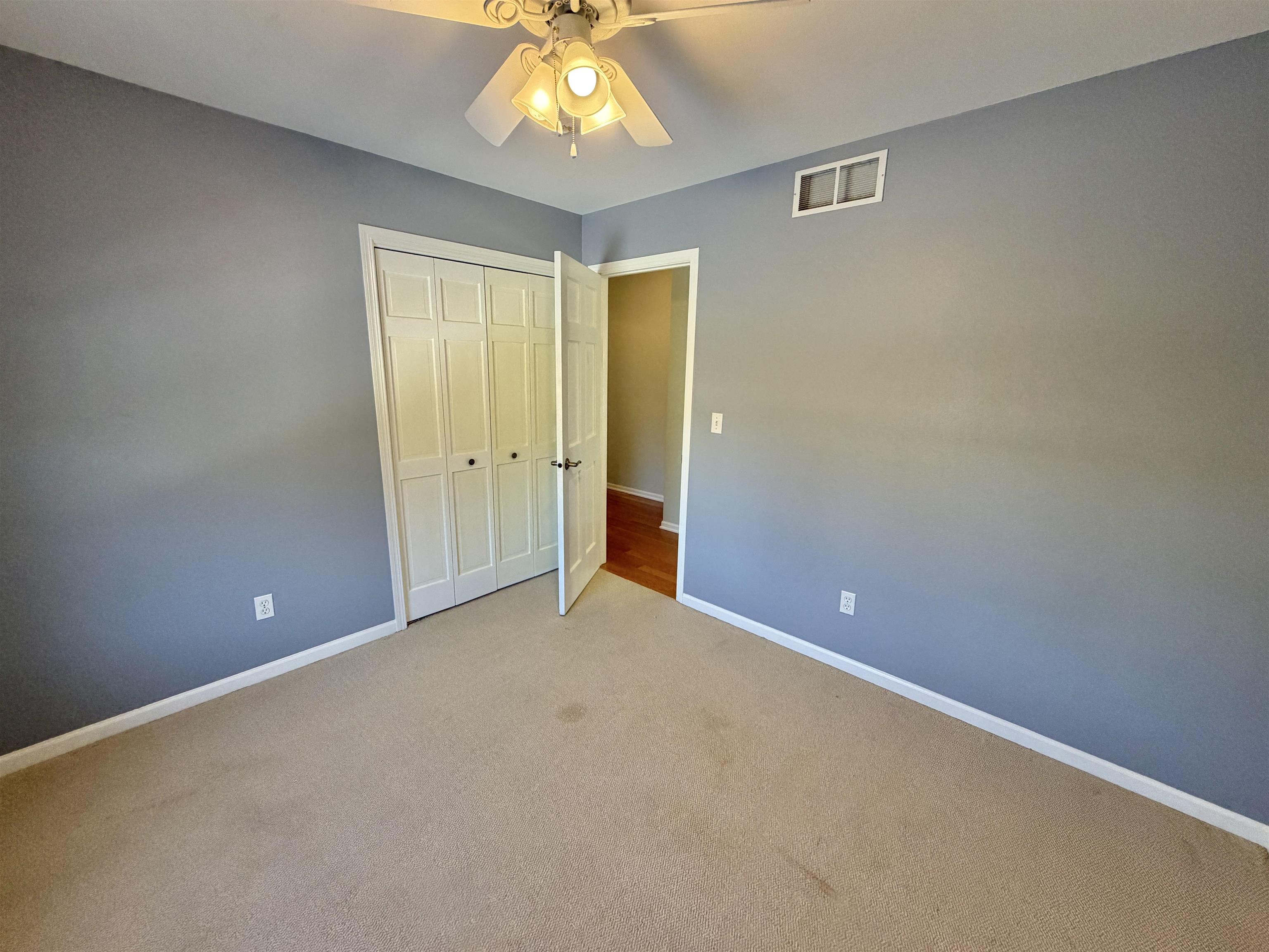 5206 East Hubbard Trail Byron, IL 61010 - Photo 51 of 52 an empty room with a chandelier fan and windows