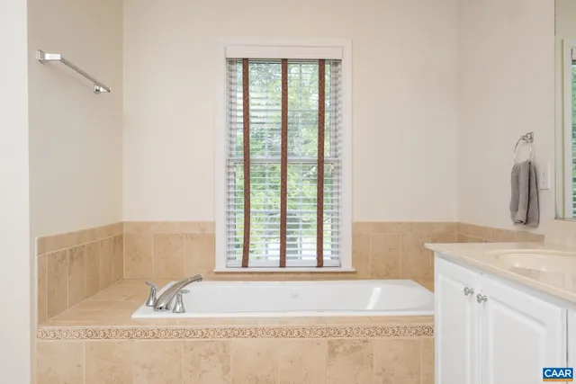a bathroom with a tub sink and mirror