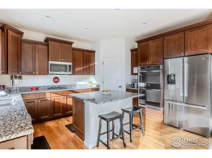 a kitchen with stainless steel appliances granite countertop a refrigerator stove microwave and sink