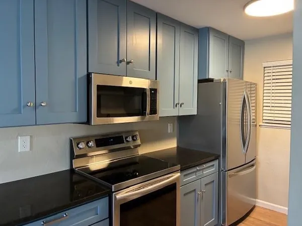 a kitchen with a refrigerator and a stove top oven