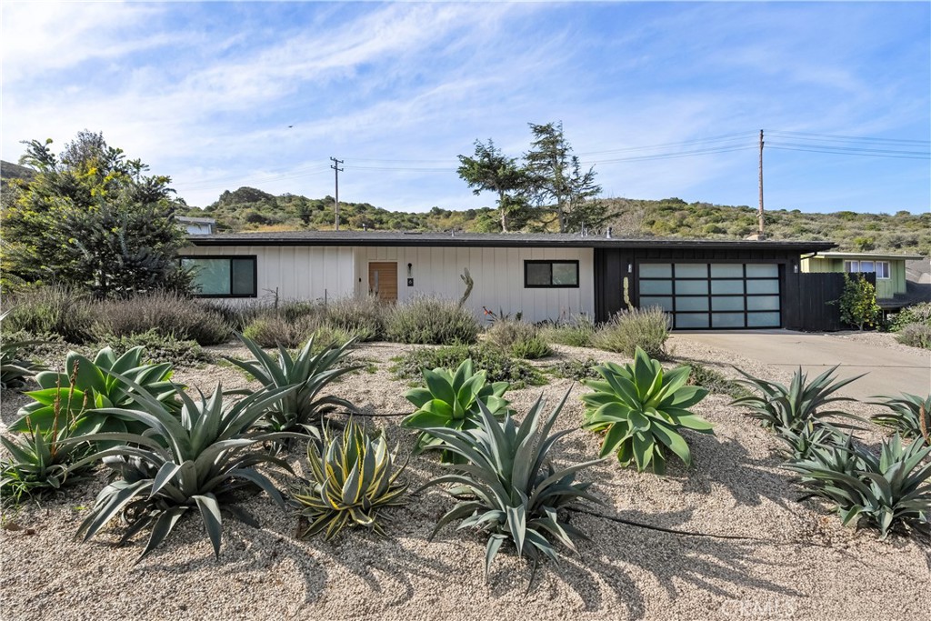 a front view of a house with yard and glass top table and chairs