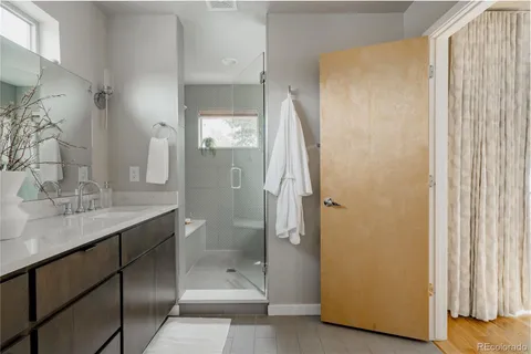 a bathroom with a granite countertop sink a mirror and a shower