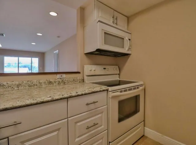 a kitchen with granite countertop cabinets stainless steel appliances and a sink