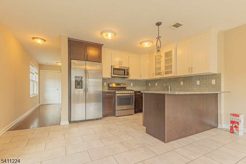 a kitchen with stainless steel appliances granite countertop a refrigerator and a sink