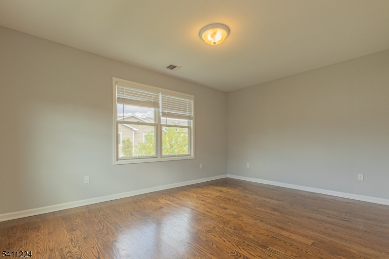 238 James Street Hackensack, NJ 07601 - Photo 11 of 24 an empty room with wooden floor and windows