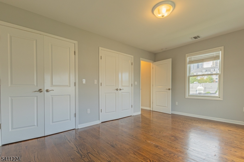 238 James Street Hackensack, NJ 07601 - Photo 10 of 24 an empty room with wooden floor and windows