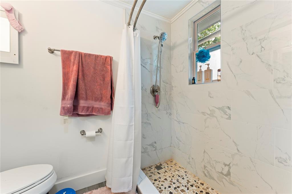 1335 40th Street Sarasota, FL 34234 - Photo 13 of 50 a bathroom with a toilet and shower curtain