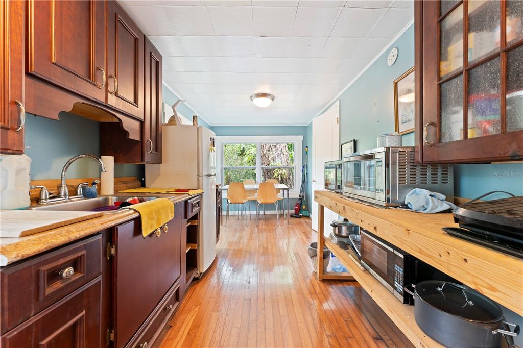 1335 40th Street Sarasota, FL 34234 - Photo 26 of 50 a kitchen with stainless steel appliances granite countertop lots of counter space and wooden floors