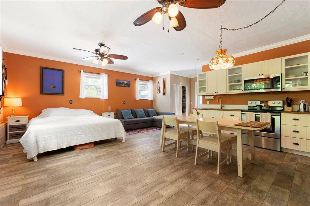 1335 40th Street Sarasota, FL 34234 - Photo 3 of 50 a bedroom with a bed a chandelier and flat screen tv