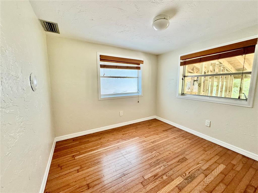 1335 40th Street Sarasota, FL 34234 - Photo 36 of 50 a view of an empty room with wooden floor and a window