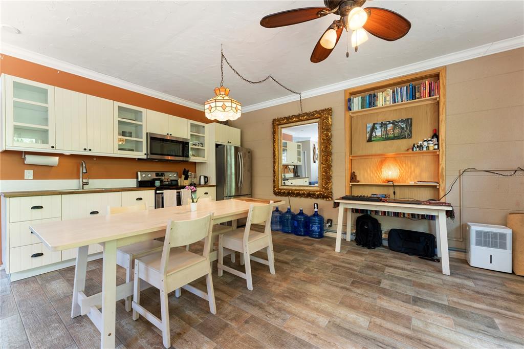 1335 40th Street Sarasota, FL 34234 - Photo 5 of 50 a kitchen with stainless steel appliances granite countertop a stove top oven a sink dishwasher and white cabinets with wooden floor