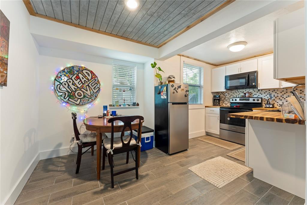 1335 40th Street Sarasota, FL 34234 - Photo 9 of 50 a kitchen with stainless steel appliances granite countertop a stove top oven a sink a dining table and chairs with wooden floor