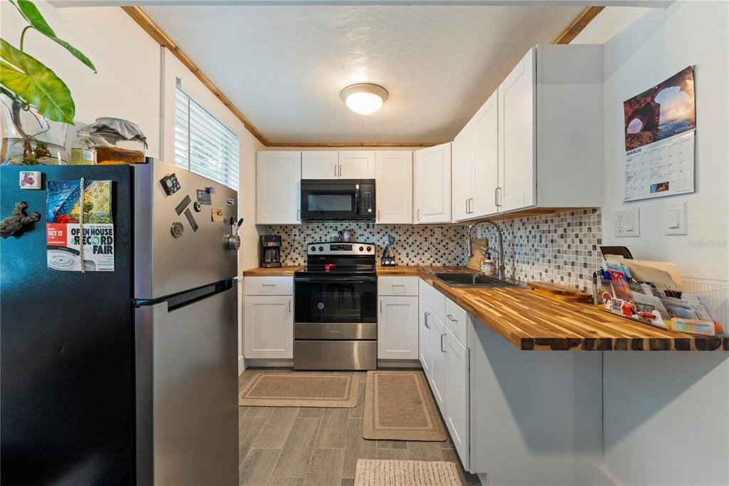 1335 40th Street Sarasota, FL 34234 - Photo 10 of 50 a kitchen with stainless steel appliances granite countertop a refrigerator a stove a sink and a microwave