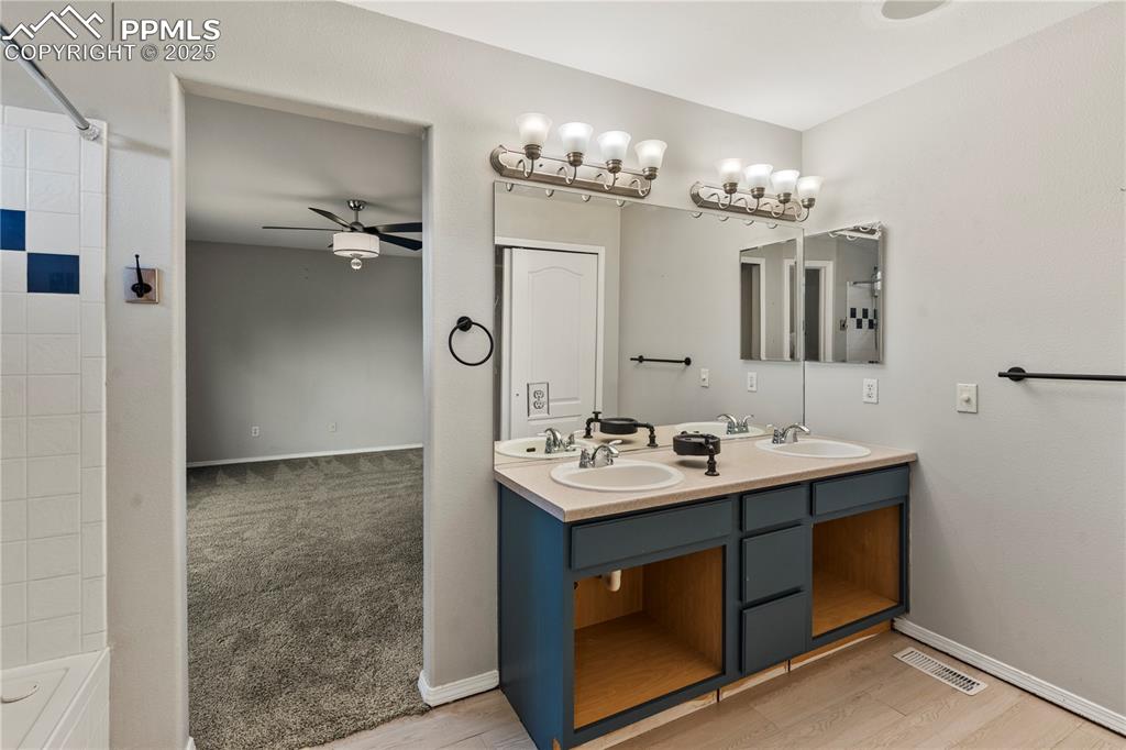 3320 Tail Spin Drive Colorado Springs, CO 80916 - Photo 12 of 28 a bathroom with a sink mirror and vanity