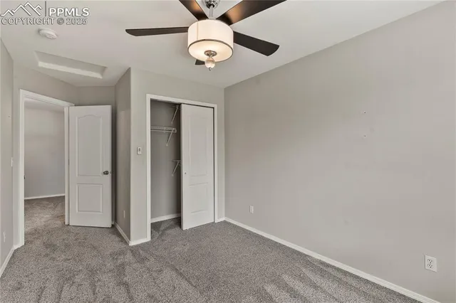 an empty room with a ceiling fan and a window