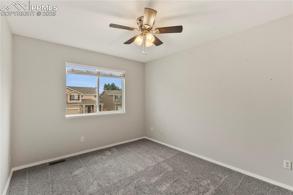 3320 Tail Spin Drive Colorado Springs, CO 80916 - Photo 22 of 28 an empty room with chandelier fan and windows