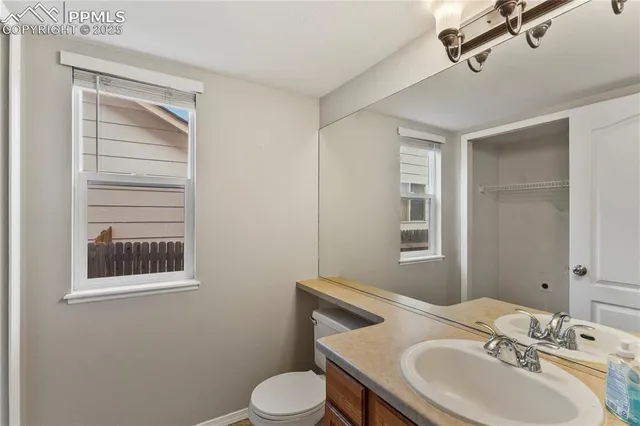 a bathroom with a toilet a sink and mirror