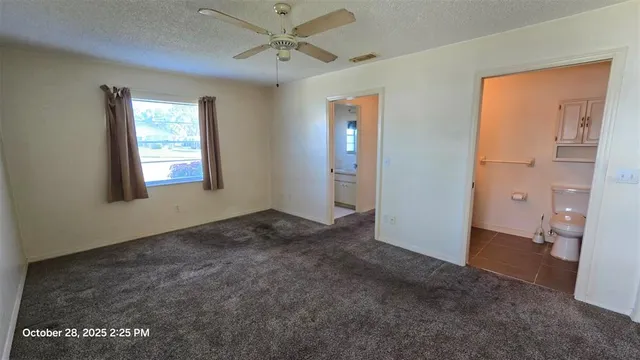 an empty room with closet and a chandelier fan