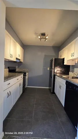 a kitchen with granite countertop a sink stove and refrigerator
