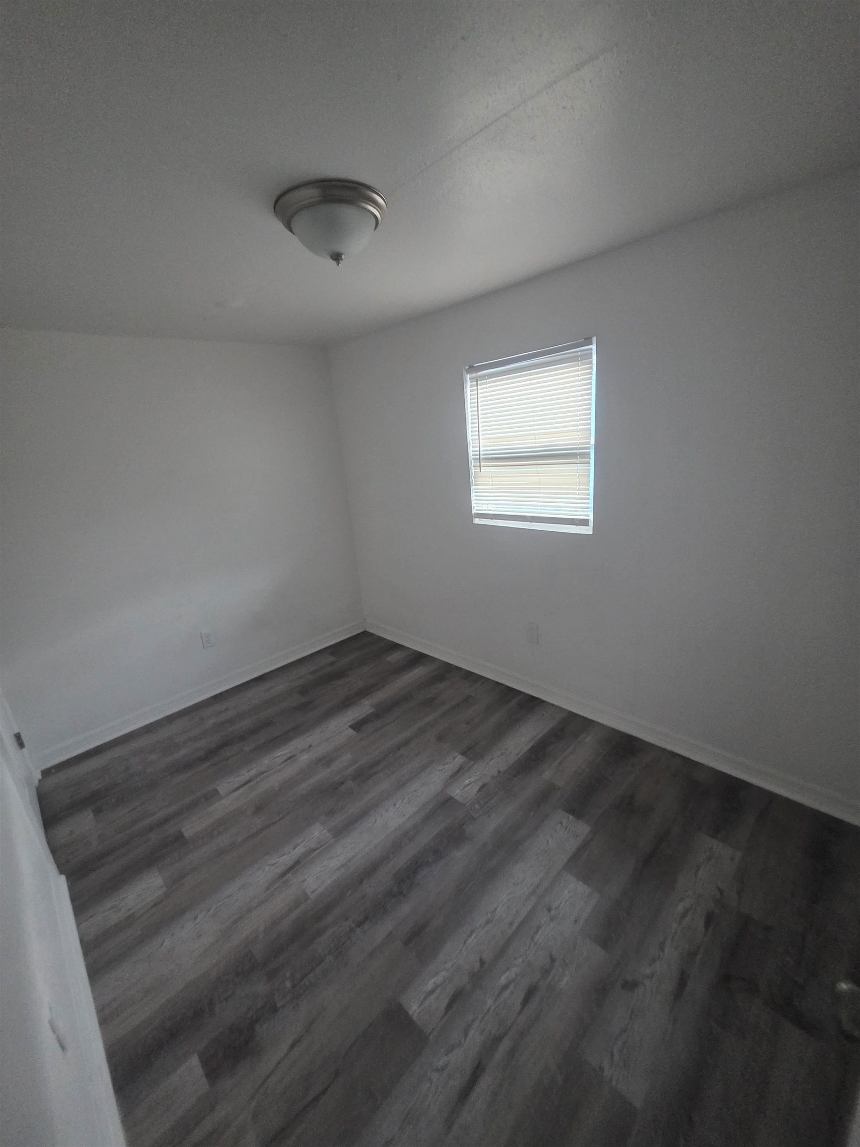 2189 Benedict Road Jacksonville, FL 32209 - Photo 7 of 19 Unfurnished room featuring dark wood-type flooring and a textured ceiling