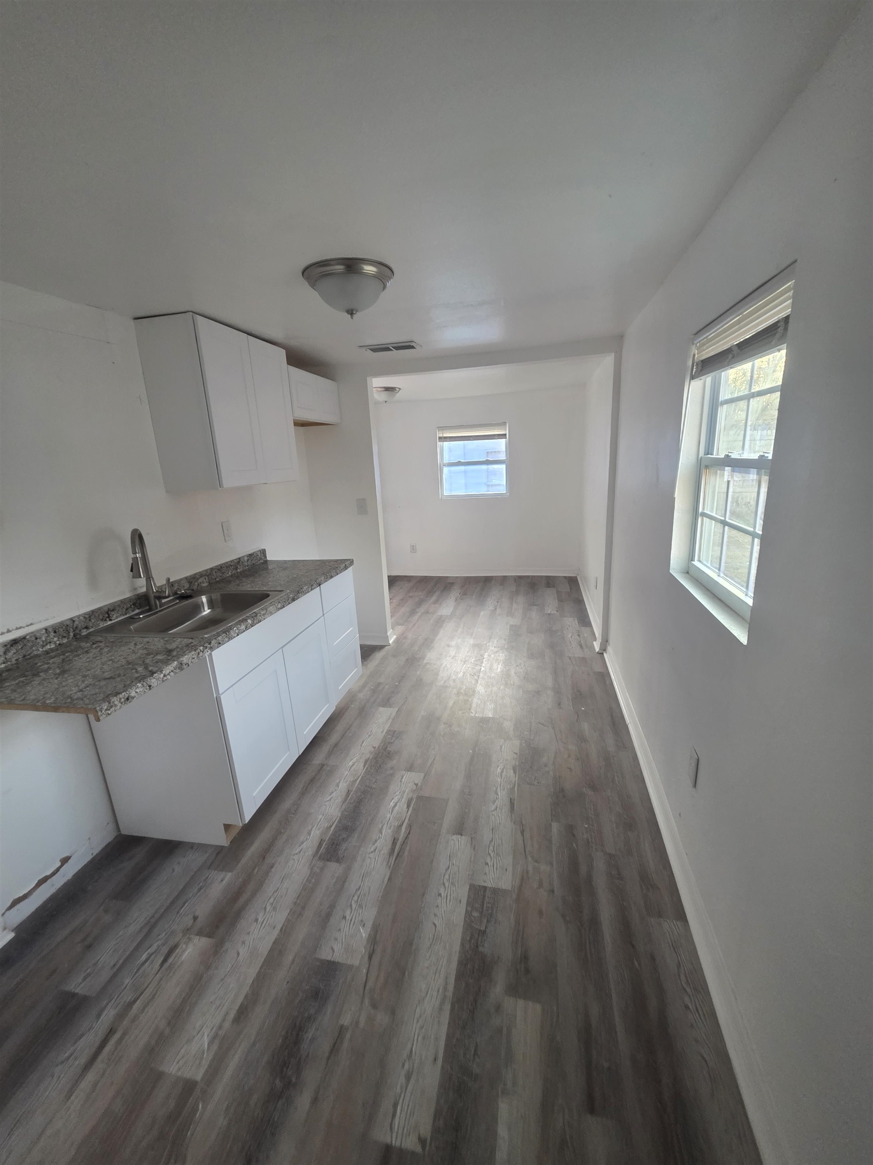 2189 Benedict Road Jacksonville, FL 32209 - Photo 10 of 19 Kitchen with white cabinetry, dark wood-style flooring, and dark countertops